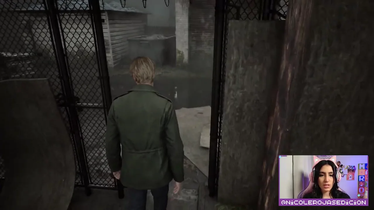James cruza una reja en Silent Hill 2; la cámara de Nicole aparece en la esquina inferior derecha.